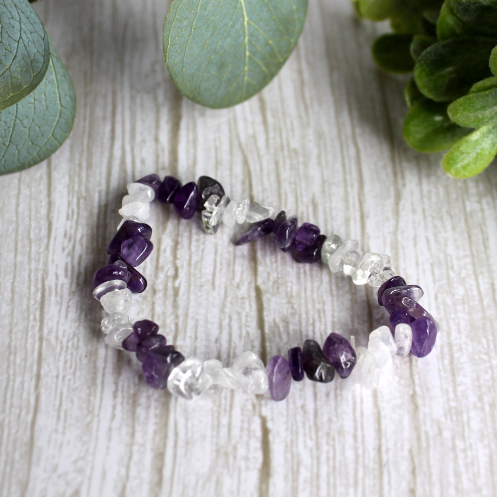 Amethyst and clear quartz stretch bracelet with natural purple and clear gemstone chips on white background
