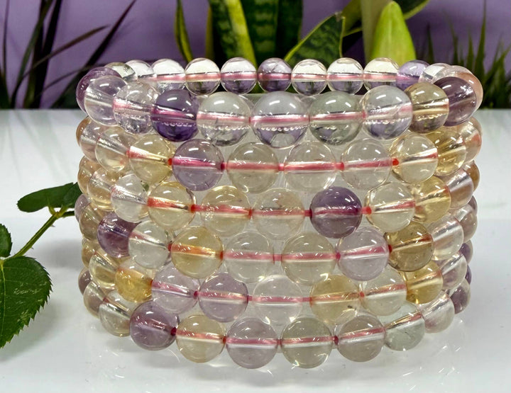 Stack of natural Ametrine crystal stretch bracelets showing purple amethyst and golden citrine bead color variation, 8mm round beads