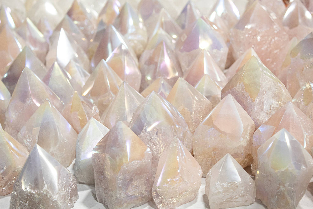 Collection of Angel Aura Rose Quartz polished tower points showing natural variation in pale pink and iridescent rainbow shimmer from platinum silver and gold bonding, sourced from Brazil