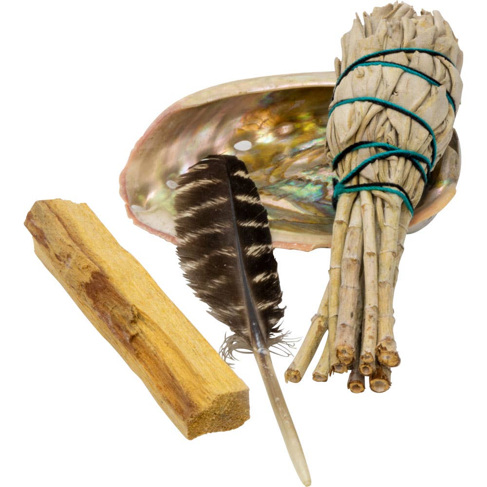Beginner smudging kit with white sage bundle, Palo Santo stick, black feather, and iridescent abalone shell on white background