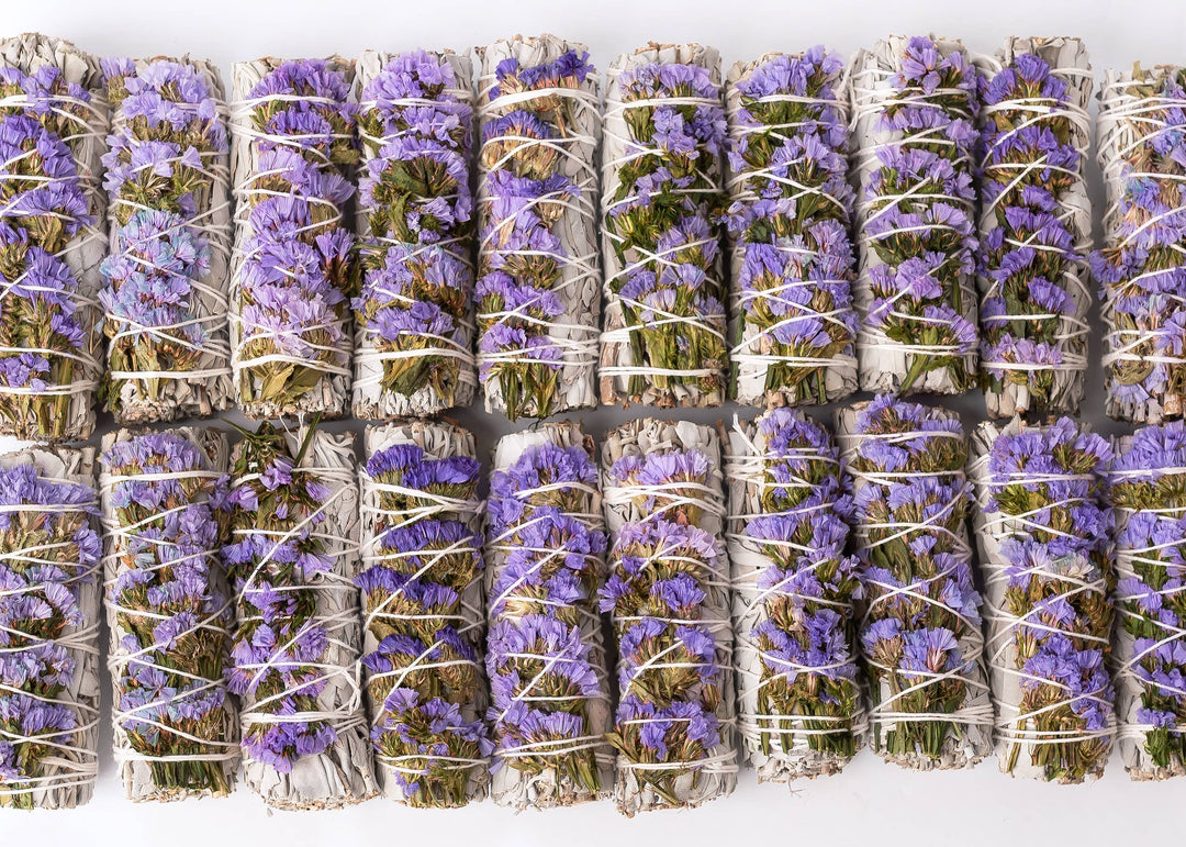 Hand-tied white sage smudge wand showing 100% cotton string binding and dried purple Statice