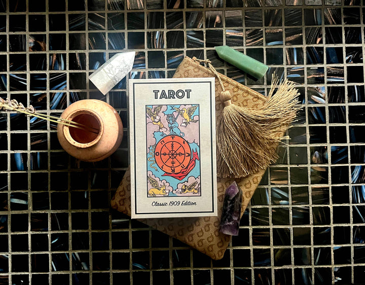Classic 1909 Tarot Deck box flat lay styled with crystals, incense, and tarot bag on dark tile background