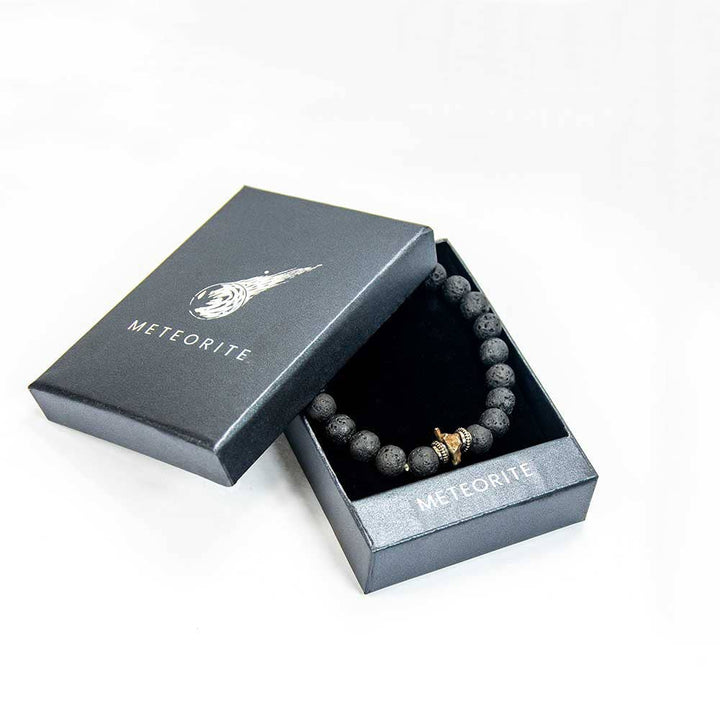 Genuine meteorite lava stone bracelet with gold meteorite bead in open black gift box with meteorite logo lid