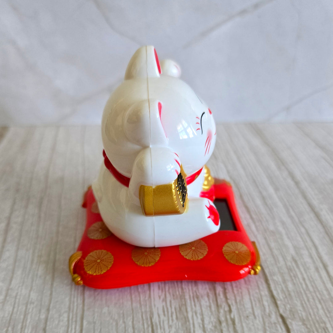 Solar powered lucky cat Maneki-Neko side view showing waving paw mechanism