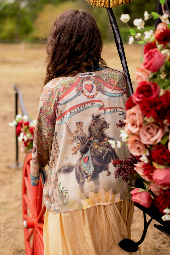 Back view of Market of Stars Love Revolution crop kimono featuring 1892 woman on horseback print with "Revolution is Love" banner, vintage florals in faded red and ivory