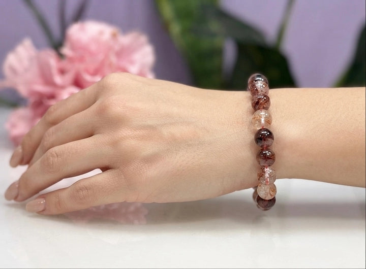 Natural Hematoid Fire Quartz 8mm crystal stretch bracelet worn on wrist, showing deep red and blush bead tones