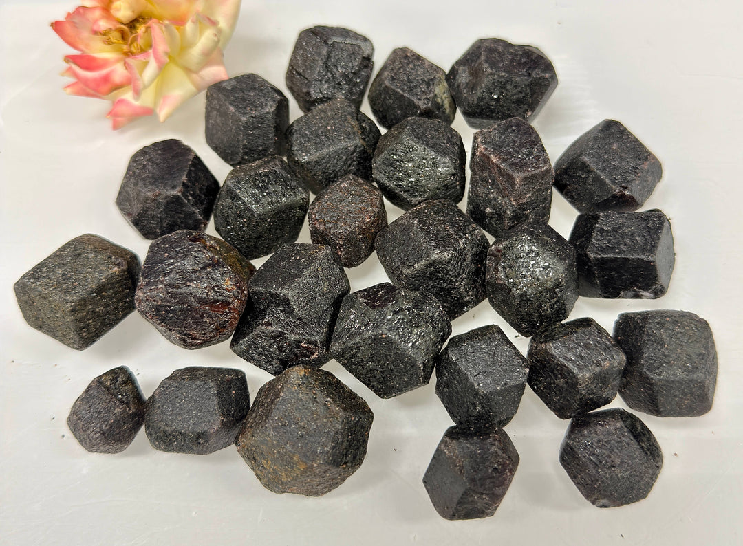 Pile of rough garnets in natural dodecahedron shape with flower accent