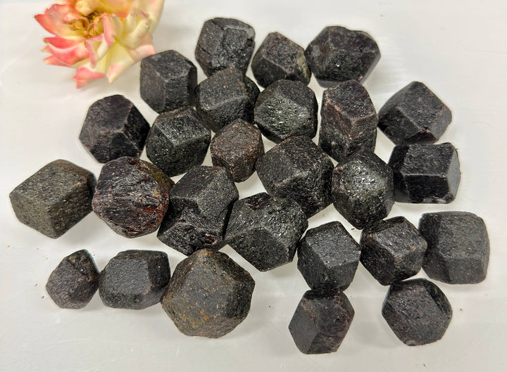 Pile of rough garnets in natural dodecahedron shape with flower accent