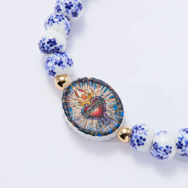 Close-up of Sacred Heart medal with authentic Lourdes holy water on porcelain bracelet