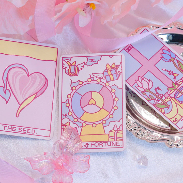 Strange Daisy Tarot 79-card deck spread showing whimsical Rider-Waite inspired artwork in pink and The Seed card