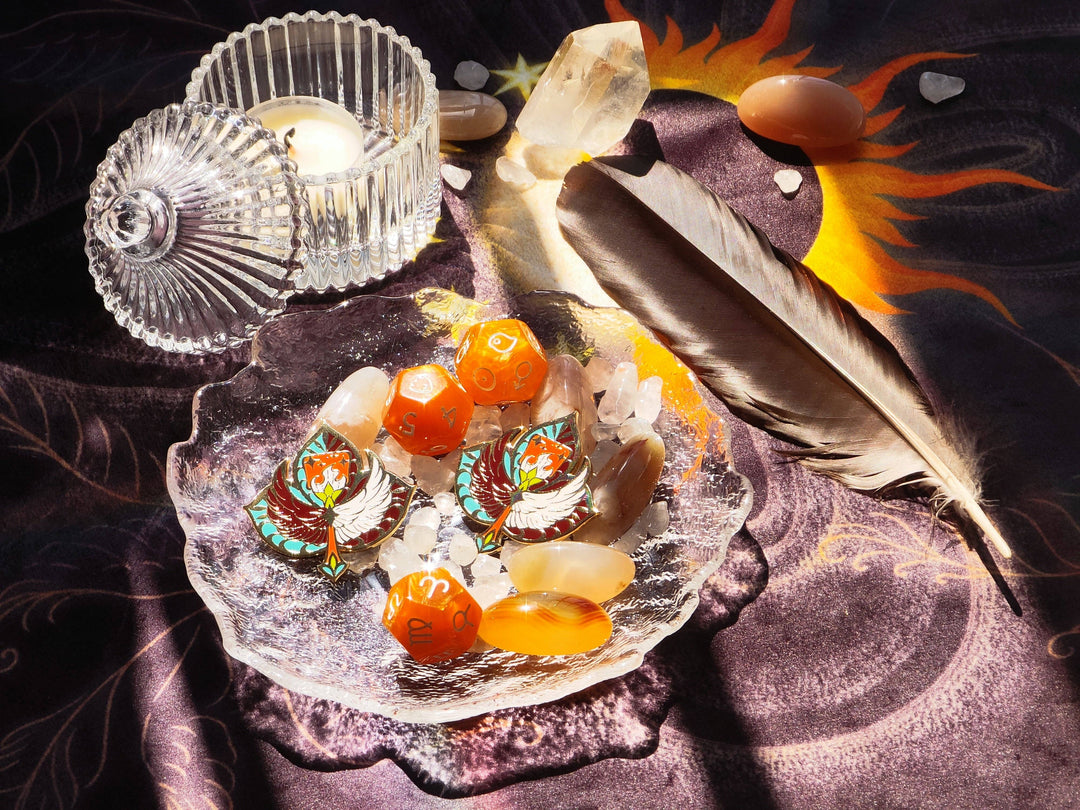 Sun and Moon Tarot Cloth styled as altar backdrop with crystals, feather, enamel pins, and candle in a spiritual reading setup