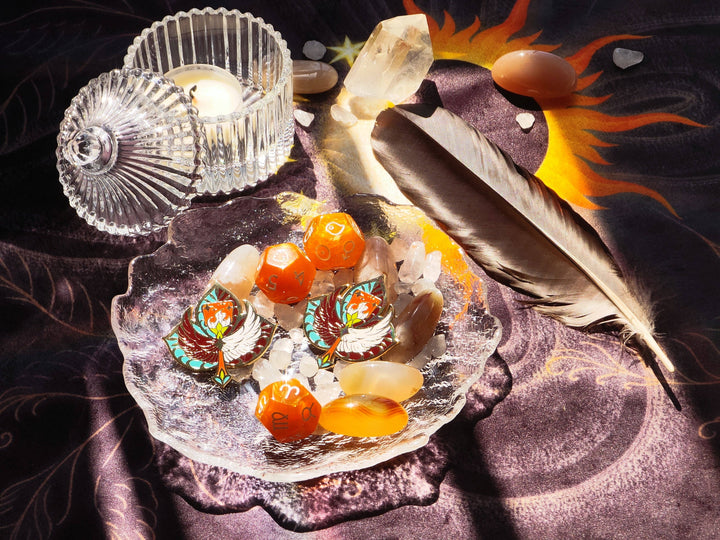 Sun and Moon Tarot Cloth styled as altar backdrop with crystals, feather, enamel pins, and candle in a spiritual reading setup