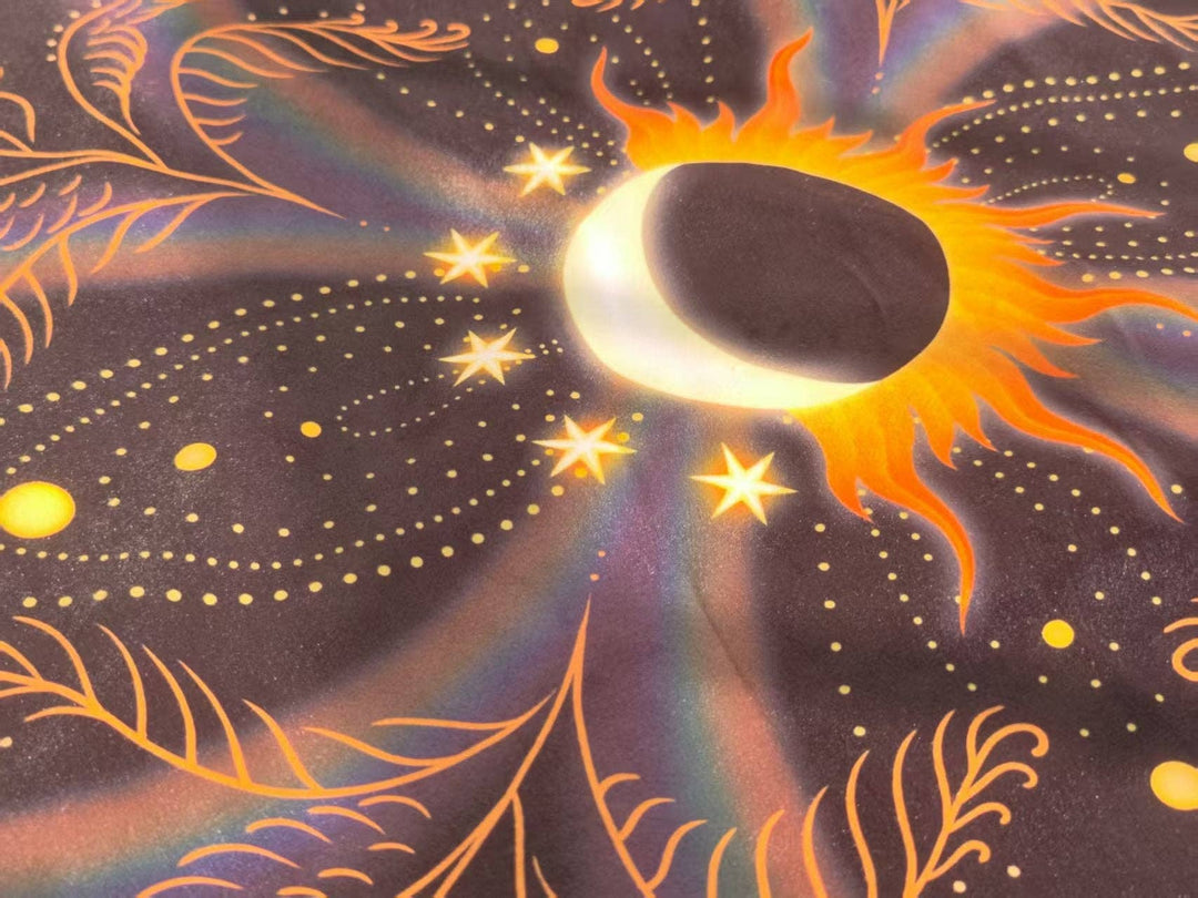 Angled detail of Sun and Moon Tarot Cloth showing solar eclipse, glowing stars, and botanical swirl pattern in deep purple and gold tones