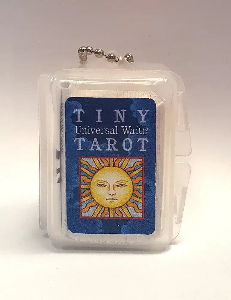 Close-up of the Tiny Universal Waite Tarot deck in its clear key chain case, showing the blue sun-design label and silver ball chain.