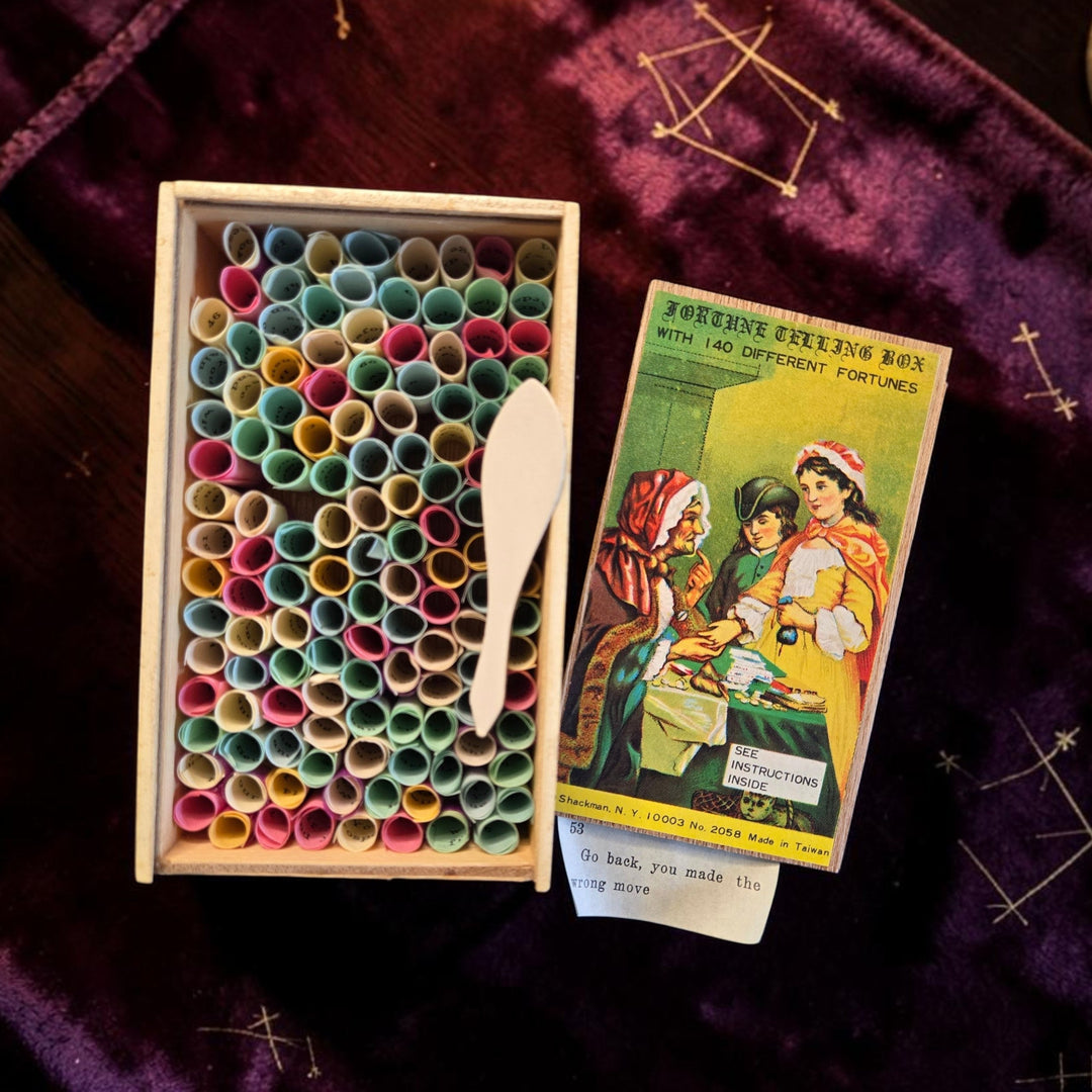 Open vintage Fortune Telling Box showing 140 colorful rolled paper fortunes and a sample fortune slip reading "Go back, you made the wrong move" — 1970s Taiwan collectible