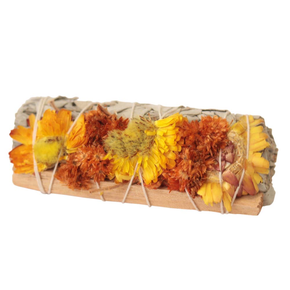 White sage and palo santo smudge stick bundle with yellow strawflowers for spiritual cleansing and meditation
