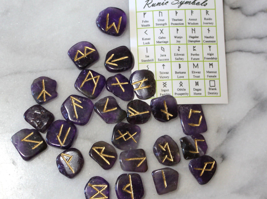 Amethyst Elder Futhark rune stones scattered with symbol reference card — Viking rune set by Healing Winds Emporium