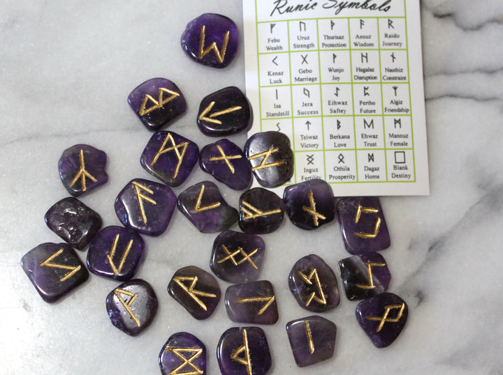 Amethyst Elder Futhark rune stones scattered with symbol reference card — Viking rune set by Healing Winds Emporium